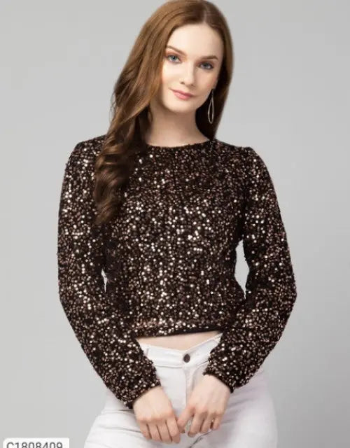 Woman wearing a sparkly black top against a gray background