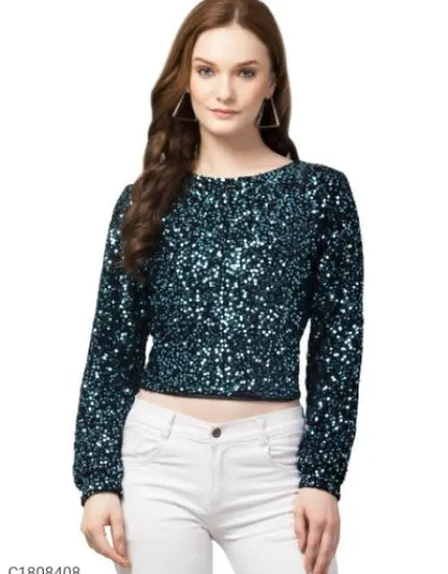 Woman wearing a dark blue sequin top and white pants on a white background