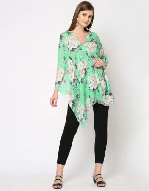 Woman wearing a green floral top and black pants on a white background