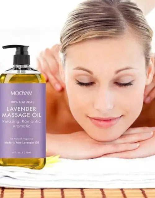 Woman receiving a massage with a bottle of lavender massage oil in the foreground.