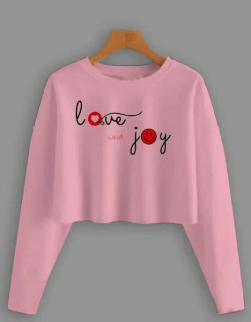 Pink long-sleeve crop top with 'love and joy' text on a gray background

