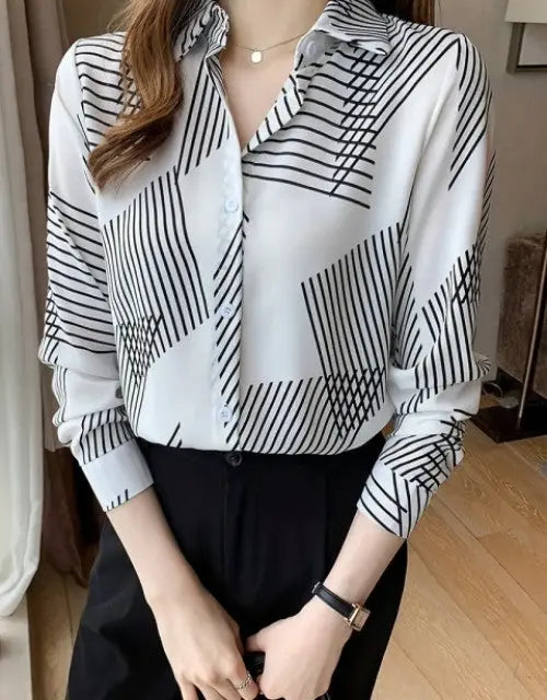 Person wearing a black and white striped shirt with a blurred background