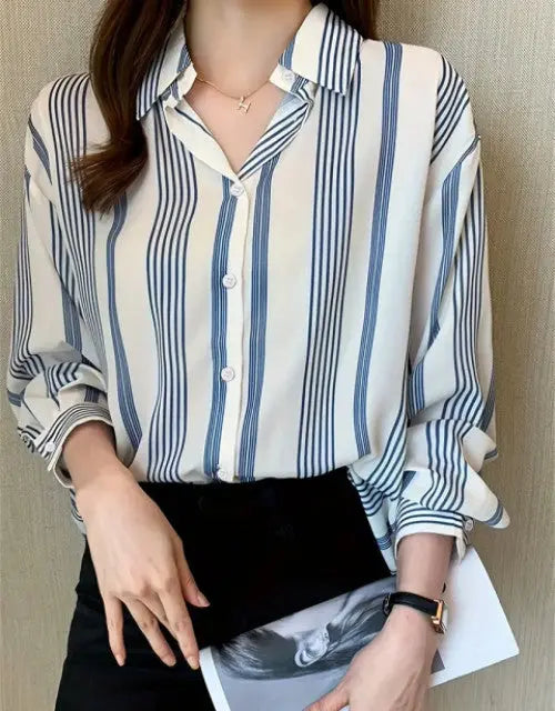 Person wearing a blue and white striped shirt holding a black clutch.