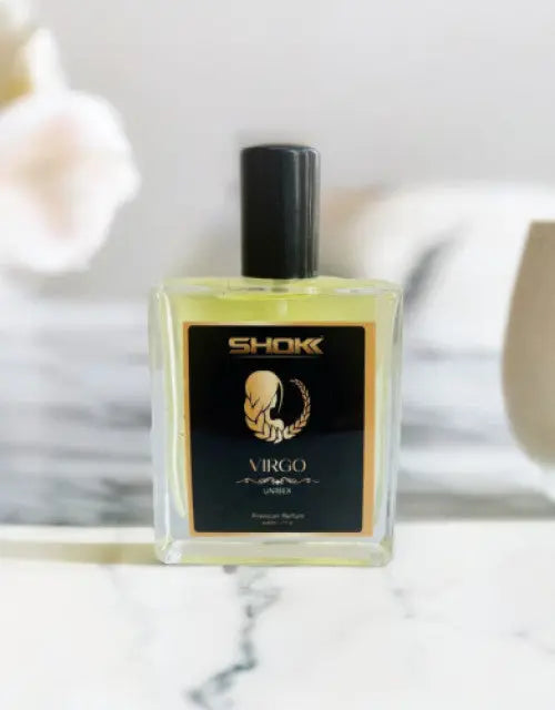 Perfume bottle labeled 'SHOK Virgo' on a marble surface with a blurred background


