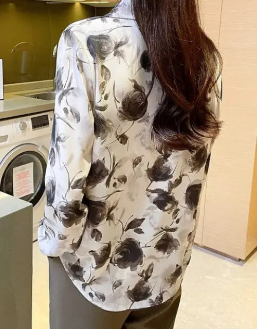 Person wearing a floral-patterned shirt in a kitchen setting