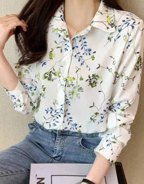 Woman wearing a floral blouse and jeans against a neutral background
