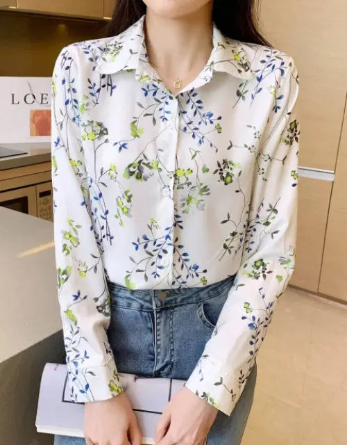 Person wearing a floral blouse with a blurred indoor background
