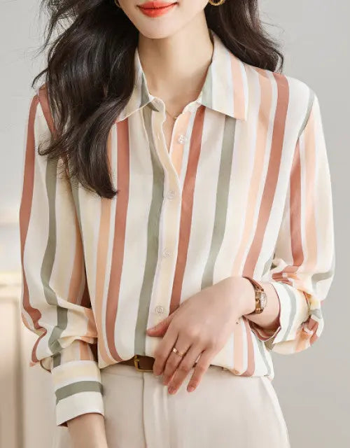 Person wearing a striped blouse with a neutral background