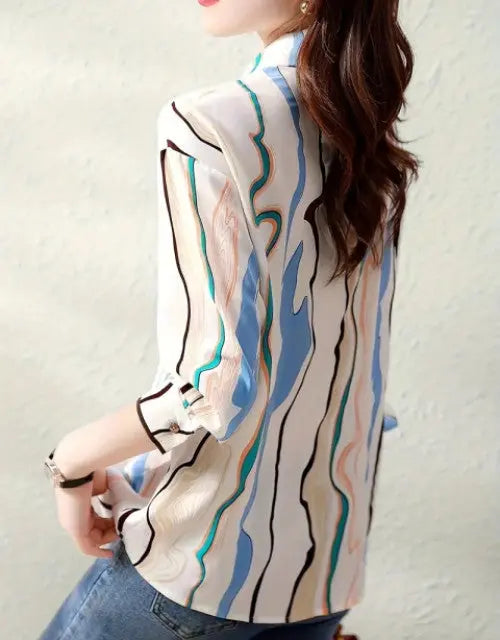 Woman wearing a patterned blouse with a plain background