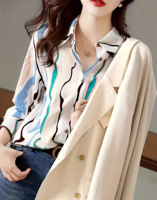 Person wearing a patterned shirt and beige coat with a neutral background