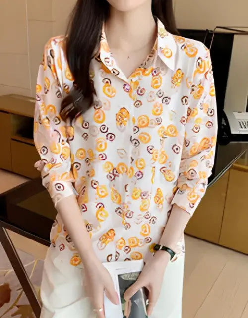 Woman wearing a patterned blouse in an indoor setting