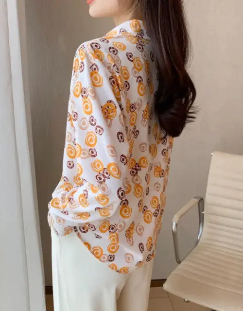 Person wearing a floral patterned shirt with a neutral background