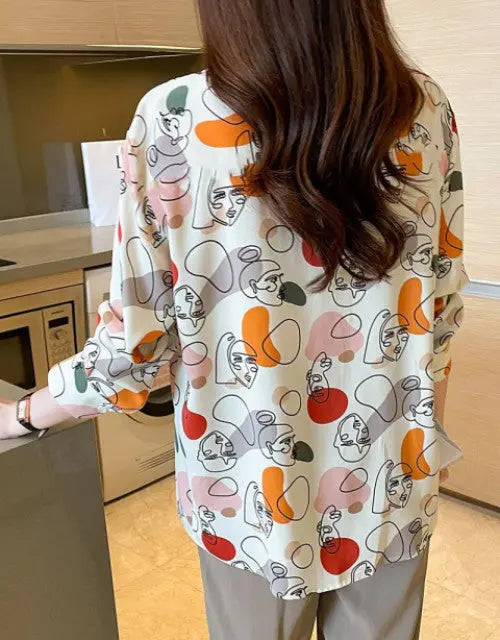 Person wearing a colorful patterned shirt in a kitchen setting