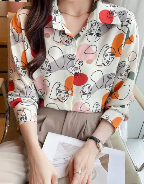 Person wearing a patterned shirt sitting at a desk.