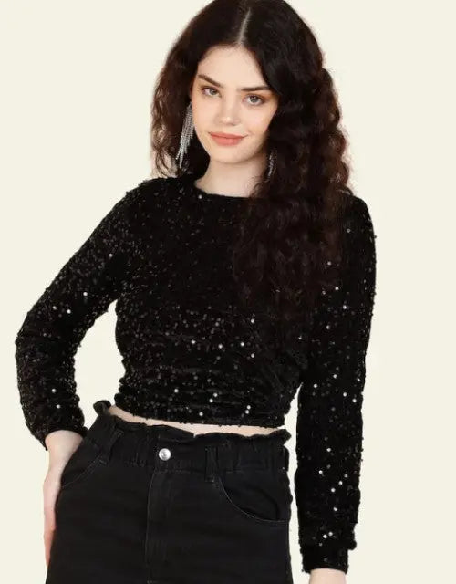 Woman wearing a black sequin top against a beige background