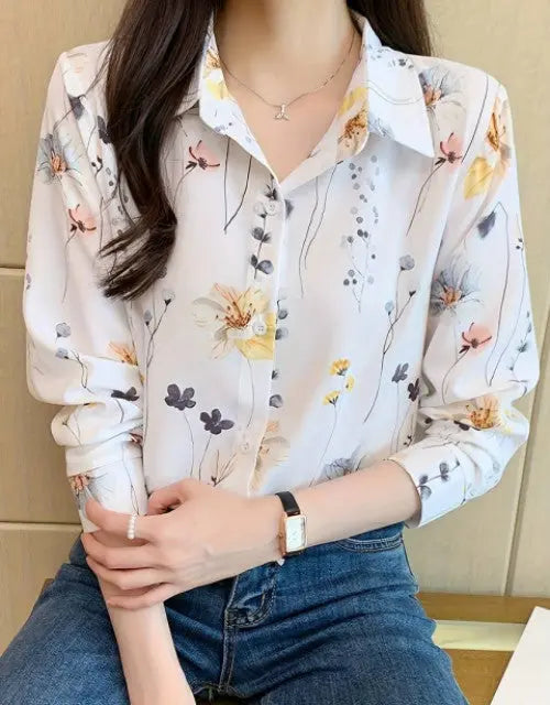 Person wearing a floral blouse with a neutral background